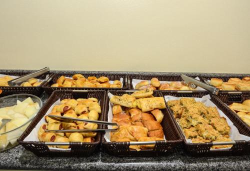 a bunch of trays filled with different types of food at Hotel Goiânia in Tucuruí
