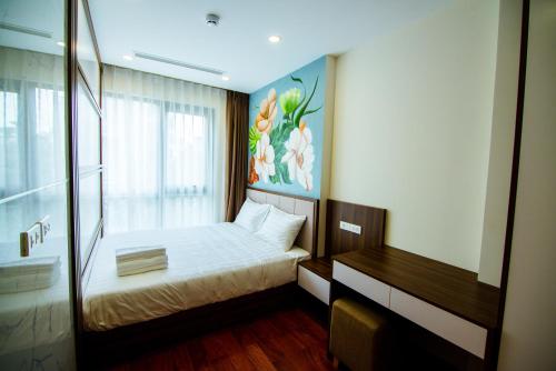 a small bedroom with a bed and a desk at HANA Stay in Hanoi