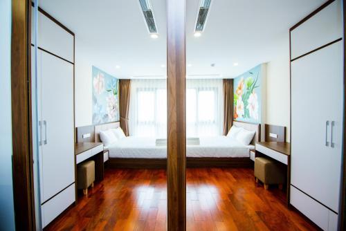a bedroom with a bed and two windows at HANA Stay in Hanoi