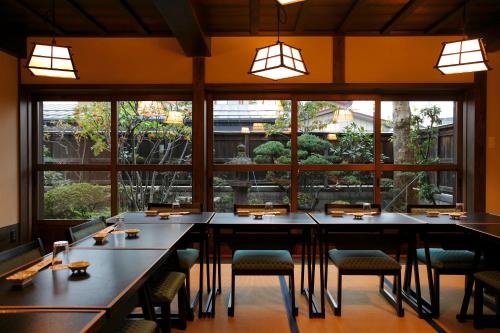 会津若松市にある料理旅館　田事のテーブルと椅子、大きな窓のあるレストラン