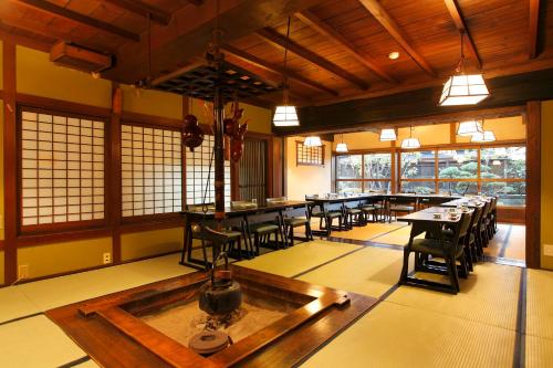 a dining room with tables and chairs and windows at Tagoto in Aizuwakamatsu