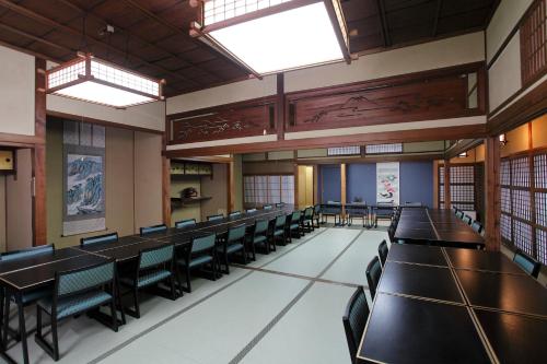 Habitación grande con mesas, sillas y ventanas. en Tagoto en Aizuwakamatsu