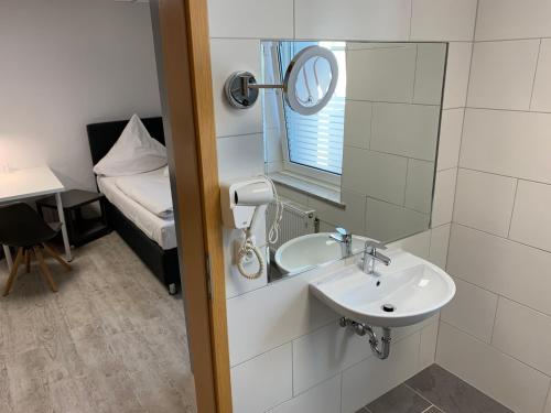 La salle de bains est pourvue d'un lavabo, d'un miroir et d'un lit. dans l'établissement Casino Hotel Neubeckum, à Neubeckum