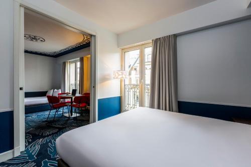 une chambre d'hôtel avec un lit et une table dans l'établissement Aparthotel Adagio Paris Haussmann Champs Elysées, à Paris