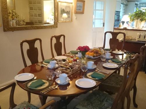 una mesa de madera con platos y cuencos de fruta. en Stone House en Sulgrave