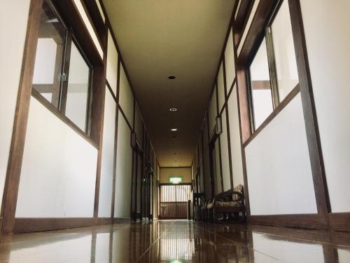 an empty hallway with large windows in a building at Bunanoyado Koase in Aga