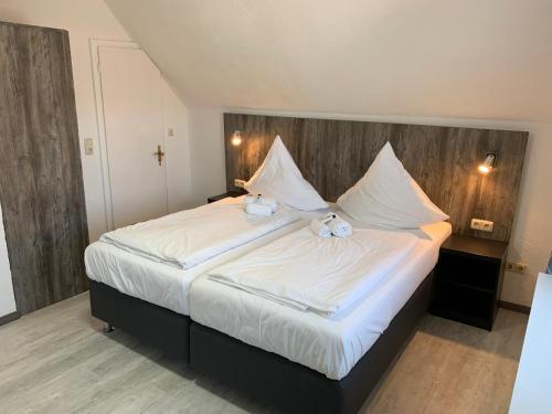 a bedroom with a large bed with two teddy bears on it at Casino Hotel Neubeckum in Neubeckum