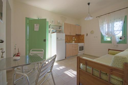 a kitchen and dining room with a table and a refrigerator at Anemohadi Apartments in Kastrisiánika