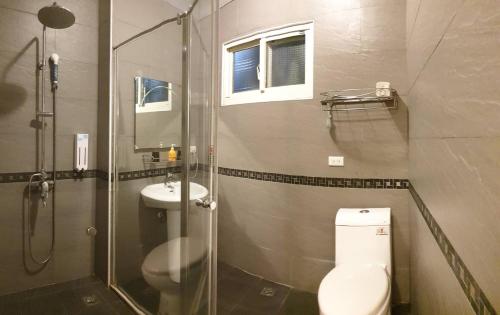 een badkamer met een douche, een toilet en een wastafel bij Happiness Yes Hostel 2 in Luodong