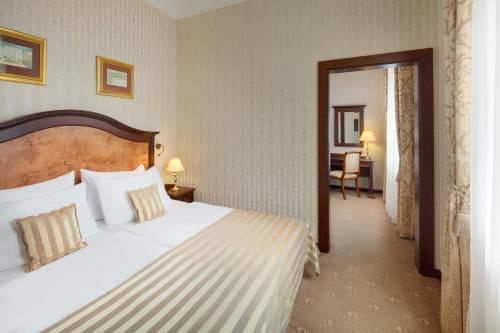 a hotel room with a large bed and a desk at Ensana Nové Lázně in Mariánské Lázně
