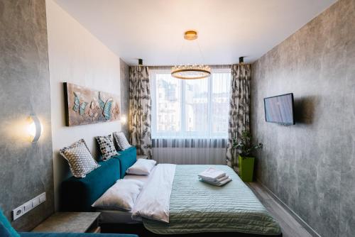 a bedroom with a bed and a blue couch at Royal Tower Luxurious Smart Residence (1) in Kyiv