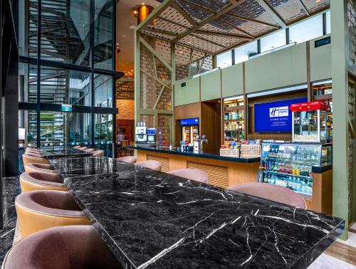 a long black counter with chairs and a bar at Holiday Inn Express Singapore Clarke Quay by IHG in Singapore