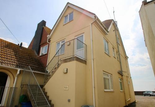 a yellow house with a staircase on the side of it at Mariners Hotel in Seaton
