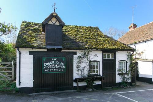a small white building with a sign on it at The Coach House, The Haywain, Bramling, Canterbury in Canterbury