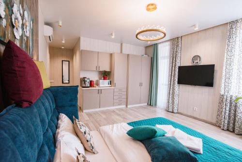 uma sala de estar com um sofá azul e uma cozinha em Royal Tower Luxurious Smart Residence (4) em Kiev
