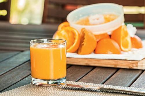 a glass of orange juice next to a plate of oranges at Villa Hierschel Droyßig in Droyßig