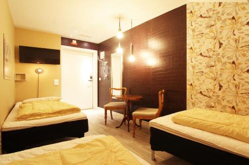 a hotel room with two beds and a table at Skanstulls Boutique Hostel in Stockholm