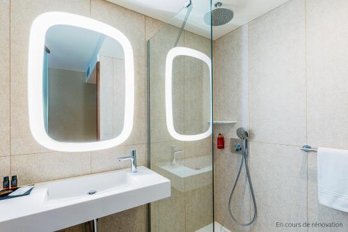 a bathroom with a sink and a mirror at Oceania Paris Porte De Versailles in Paris