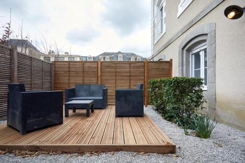 a patio with two chairs and a table on a wooden deck at Résidence Colonel in Laval