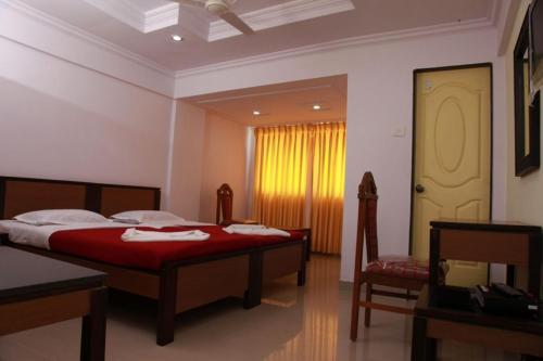 a bedroom with two beds and a window at Saiesh International Hotel in Mapusa