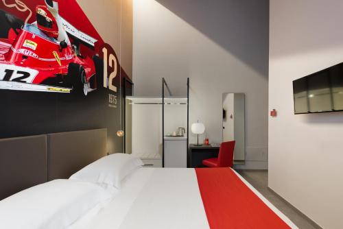 a bedroom with a bed with a race car on the wall at Hotel Maranello Village in Maranello
