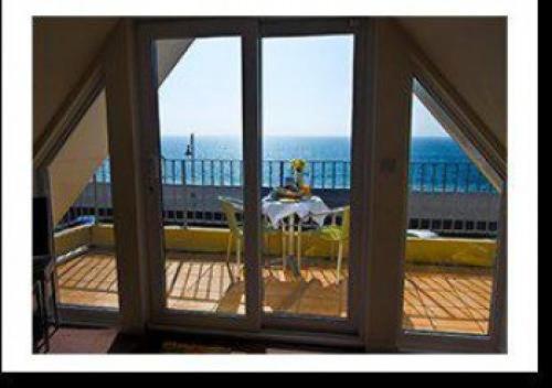 an open window with a view of the ocean from a balcony at Mariners Hotel in Seaton