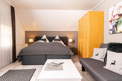 SallneckにあるGenusshotel Hirschen - Erholung im Grünen (Südschwarzwald)のベッドルーム(ベッド1台、ソファ付)