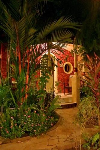 a garden with palm trees and plants in a building at "Sunny Cow" Village Villa in Anjuna