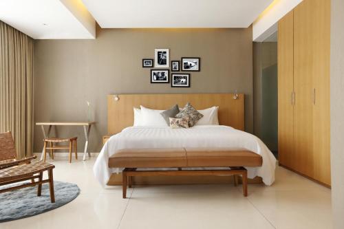 a bedroom with a large bed with a wooden headboard at Ossotel Legian in Legian