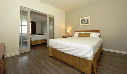 En eller flere senge i et værelse på Hotel Le Voyageur