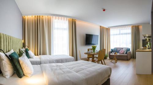a hotel room with two beds and a living room at Verde Apartments CENTRUM klimatyzacja in Koszalin