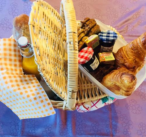 un cesto pieno di pane e dolci su un tavolo di Les cabanes de Kerellou a Plouigneau
