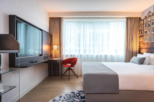 a hotel room with a bed and a television at Steigenberger Airport Hotel Amsterdam in Schiphol