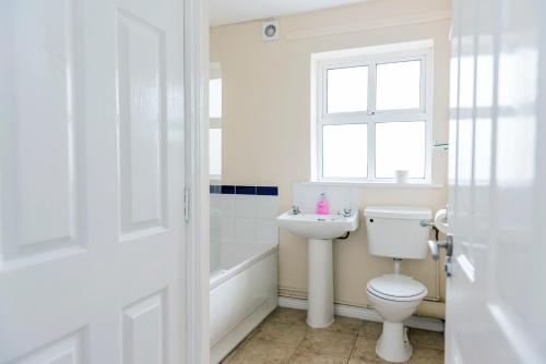 a bathroom with a toilet and a sink and a window at Marine Court Sea View in Bundoran
