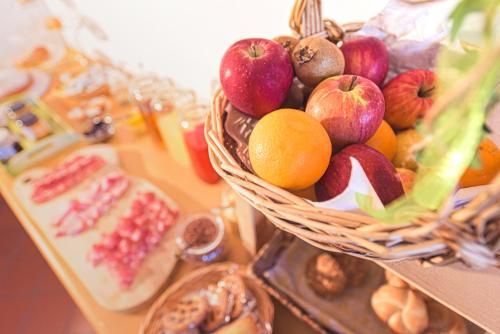 a basket of apples oranges and other fruits on a table at Agriturismo Salizzoni in Calliano
