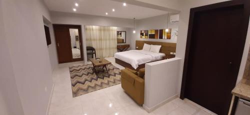 Nakhil Inn Residence في القاهرة: غرفة نوم بسرير واريكة في غرفة