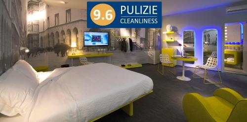 a bedroom with a bed and a tv and chairs at The Street Milano Duomo | a Design Boutique Hotel in Milan