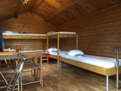 a room with two bunk beds and a table at Camping Engelbert (Groningen) in Groningen