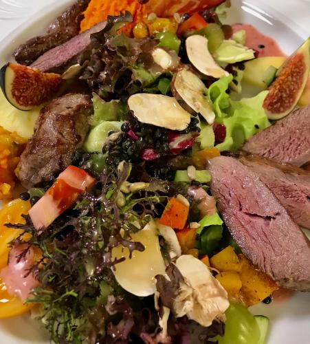 a plate of food with meat and vegetables on it at Genusshotel Hirschen - Erholung im Grünen (Südschwarzwald) in Sallneck
