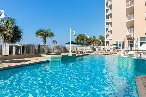 a swimming pool at a resort with palm trees at Majestic Sun in Destin