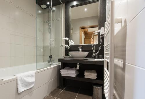 a bathroom with a sink and a mirror at Hotel Club Le Crêt in Morzine