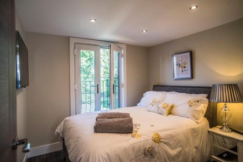Un dormitorio con una cama grande con ventana. en Courtyard Holiday Homes, en Southport