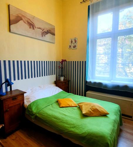 Un dormitorio con una cama con sábanas verdes y una ventana en The apartment in strict city center. Self check-in en Cracovia
