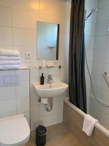 uma casa de banho com um lavatório, um WC e um espelho. em DuinHotel Texel em De Koog