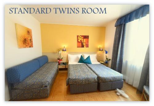 a hotel room with a bed and a couch at Hotel Beau Sejour in Etroubles