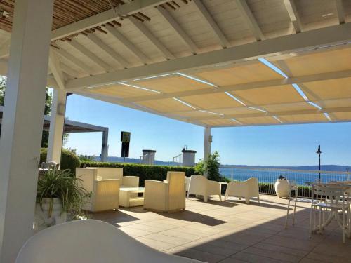 a patio with chairs and tables and a view of the ocean at Skipper White Guest House in Trevignano Romano