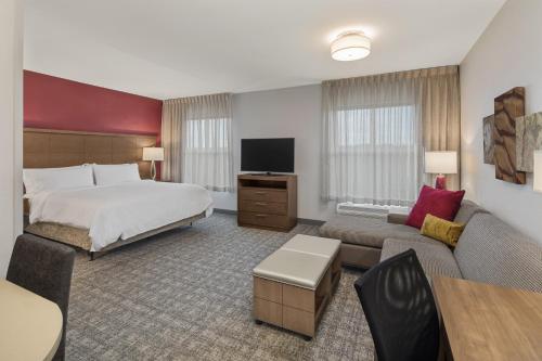 um grande quarto de hotel com uma cama e um sofá em Staybridge Suites - Florence Center, an IHG Hotel em Florence