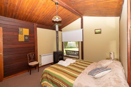 エル・カラファテにあるHostería El Galpón Del Glaciarのベッドルーム1室(ベッド1台付)