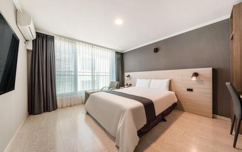 a hotel room with a bed and a large window at Gyeongpo Soo Hotel in Gangneung