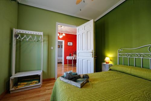 a bedroom with green and red walls and a bed at Alojamiento Rural Pueblo de la Ribera in Peñafiel